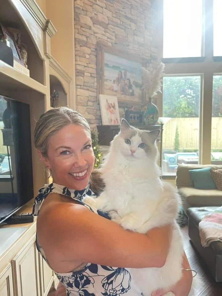 A Blossoms family in their living room with their Ragdoll